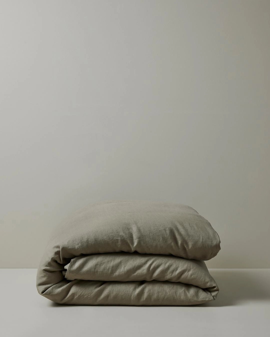 Ravello Quilt Cover in Caper, folded stack showcasing soft European linen weave and relaxed texture by Weave Home