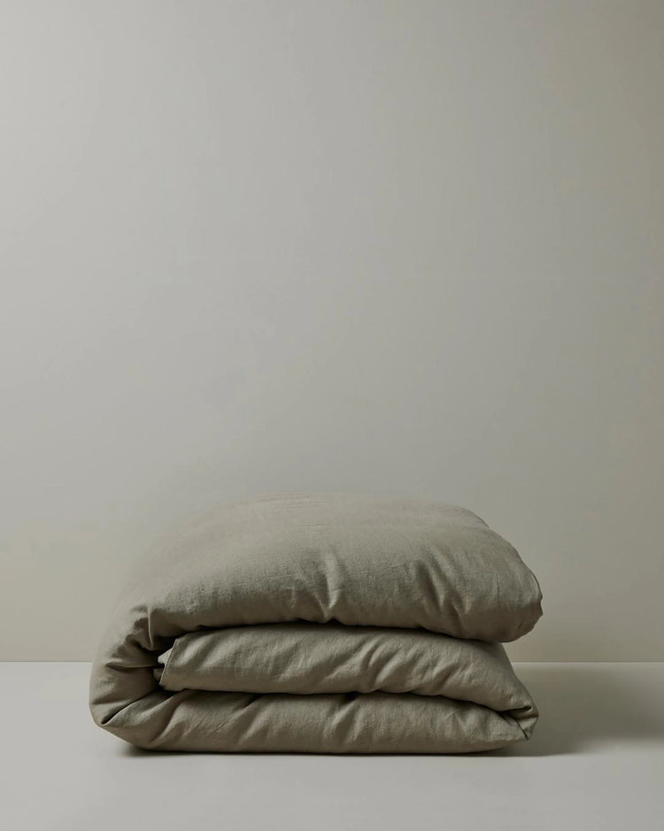 Ravello Quilt Cover in Caper, folded stack showcasing soft European linen weave and relaxed texture by Weave Home