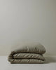 Ravello Quilt Cover in Caper, folded stack showcasing soft European linen weave and relaxed texture by Weave Home