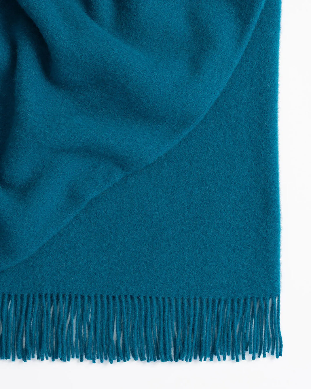 Nevis turquoise lambswool throw, close-up showing tassel border and texture-rich weave by Weave Home