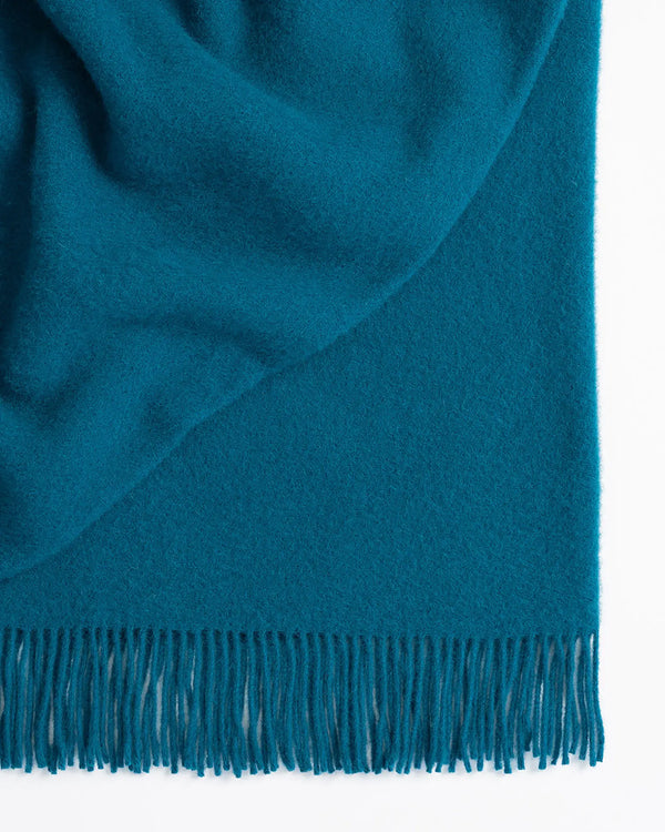 Nevis turquoise lambswool throw, close-up showing tassel border and texture-rich weave by Weave Home