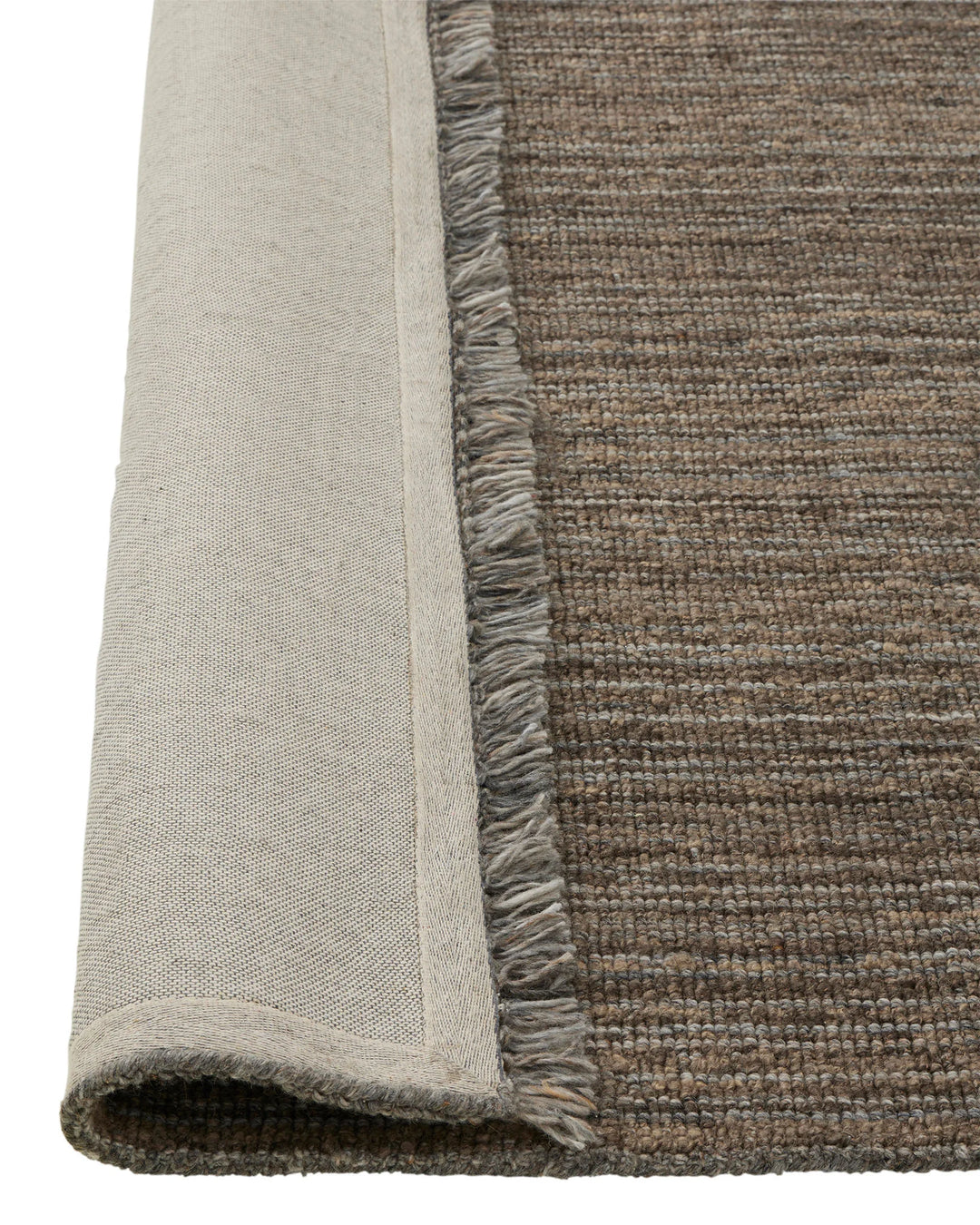 Puglia Fossil textured wool-blend rug detail showing chunky woven weave and fringe edge in muted brown-grey by Weave Home