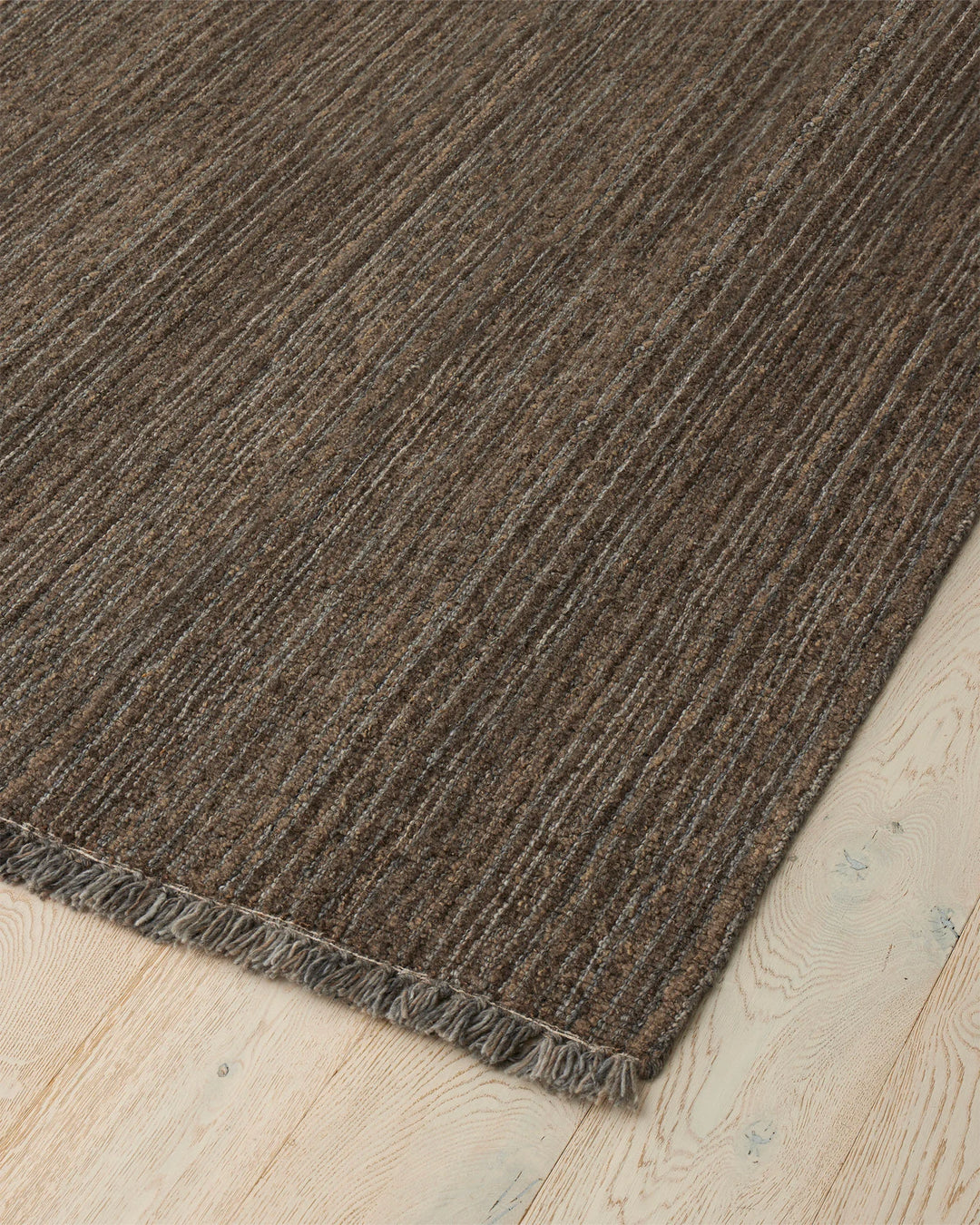Puglia Fossil rug corner detail showing chunky woven texture in muted brown and grey tones with fringe edge by Weave Home