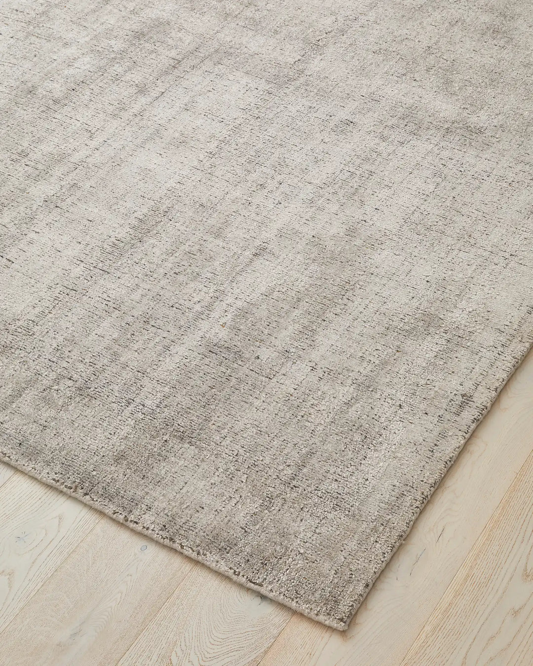 Matisse Shale rug corner detail, viscose blend low-traffic rug with salt-and-pepper texture and braided cotton edge by Weave Home