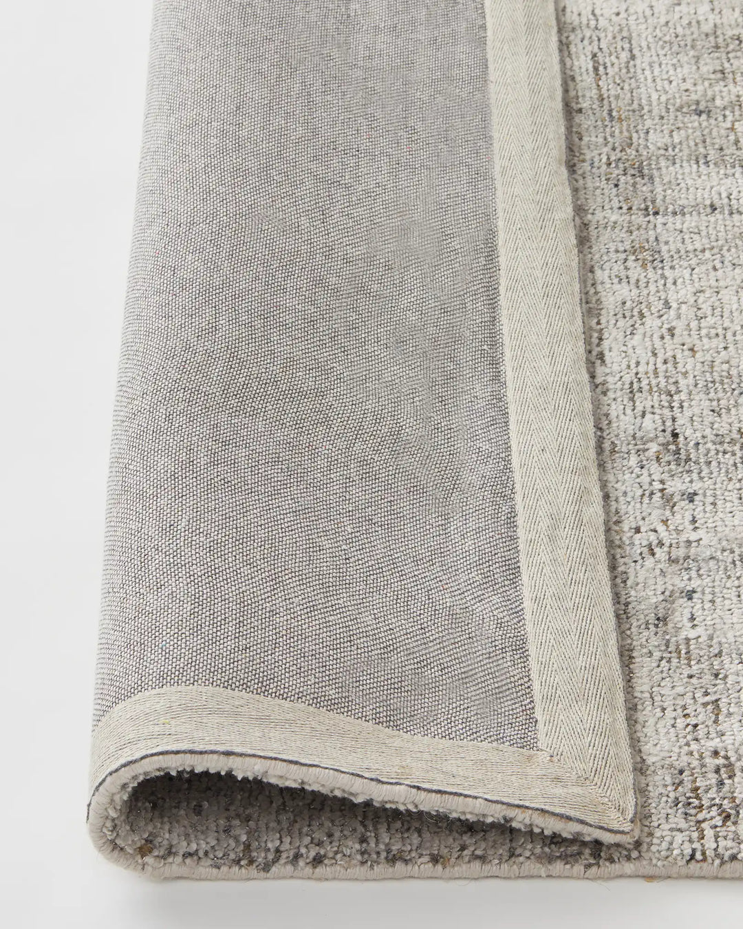 Matisse Shale rug detail showing cotton braided edge and backing, viscose blend low-traffic rug by Weave Home