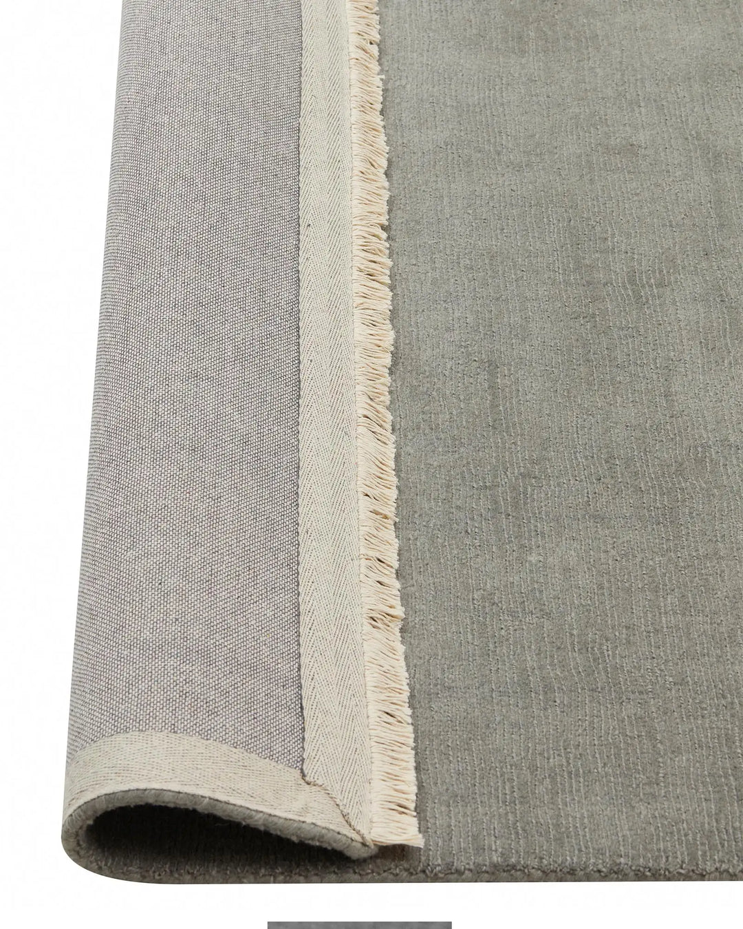 Alessandre Mineral rug detail view showing hand-woven NZ wool with natural fringe edge and cotton backing by Weave Home
