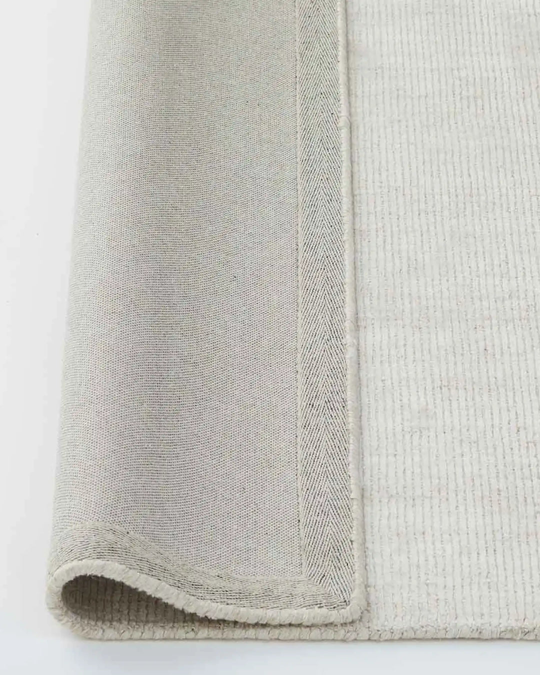 Travertine Buff rug detail, showing viscose-wool weave texture and cotton backing edge by Weave Home