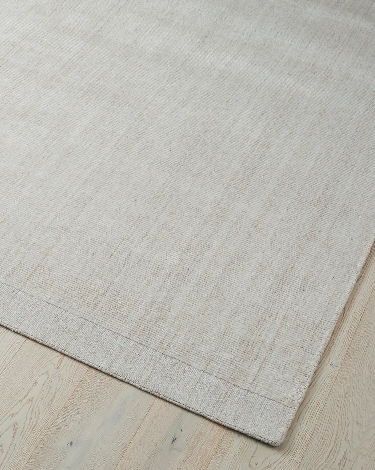 Travertine Buff rug corner detail, soft hand-woven viscose blend with marbled texture and cotton edging by Weave Home