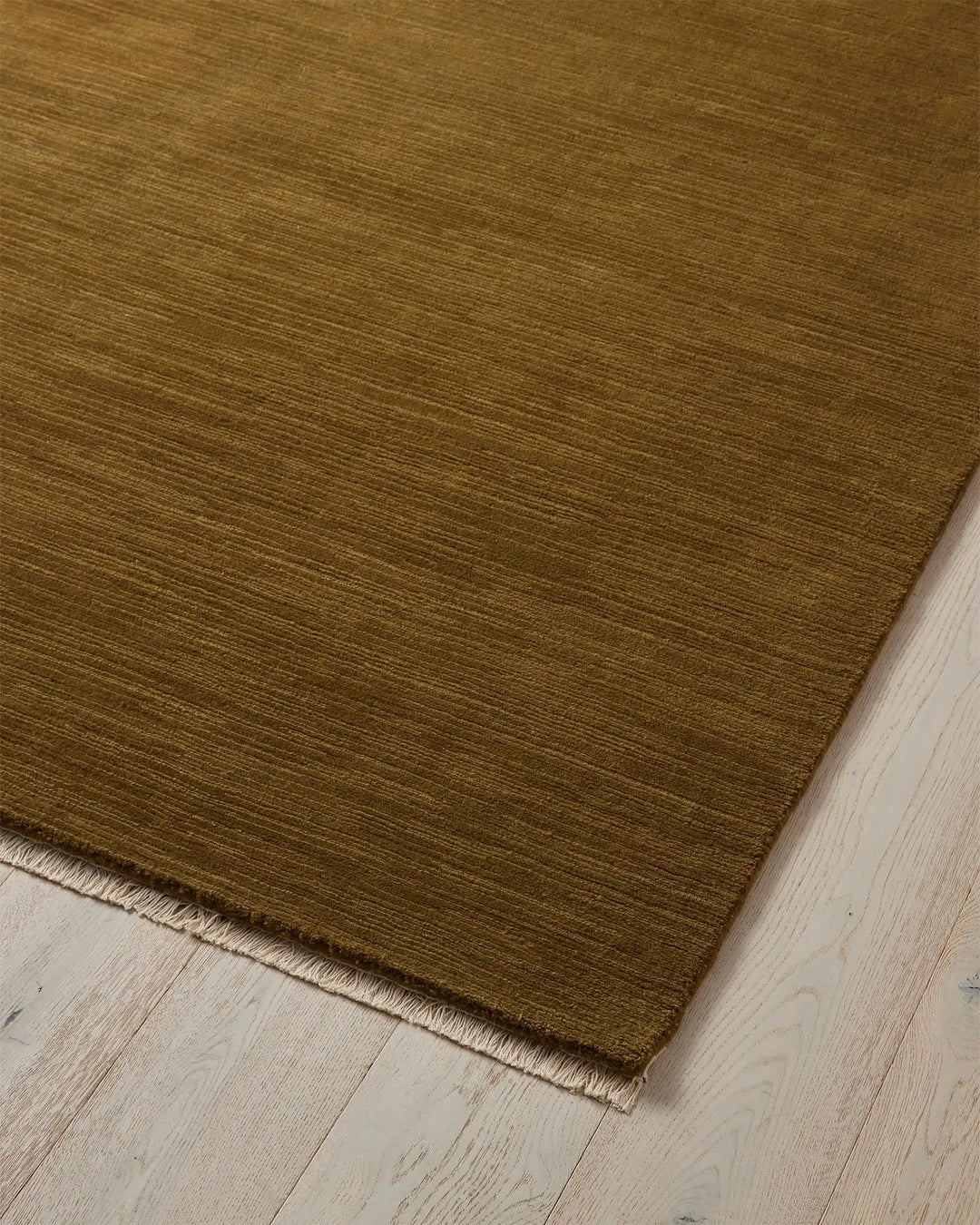 Alessandre Oakmoss handwoven wool rug in rich olive, detail view showing natural fibre texture and cotton backing by Weave Home