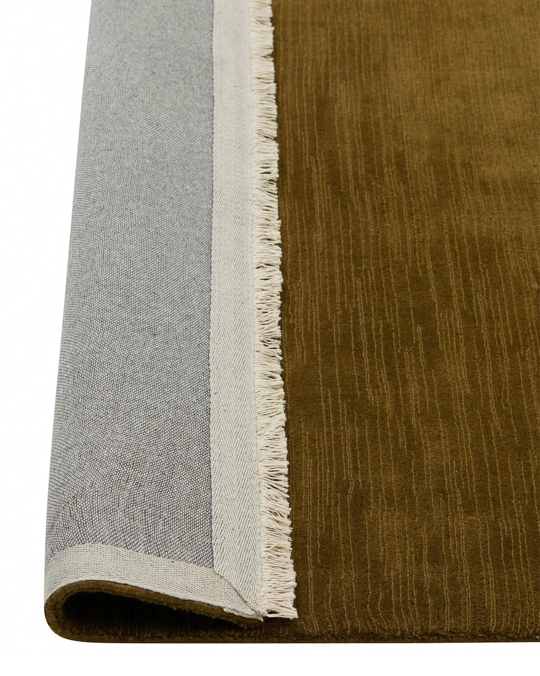 Alessandre Oakmoss rug detail, showing rich olive wool with fringe border and cotton backing by Weave Home