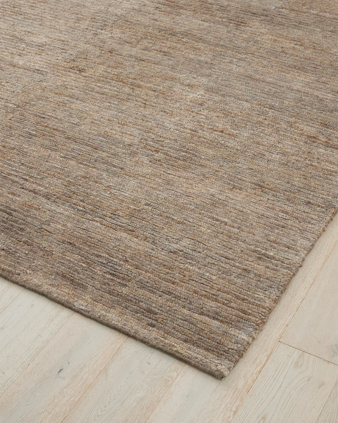 Bastian Fossil textured jute rug in rich brown with looped and cut weave detail, corner view by Weave Home