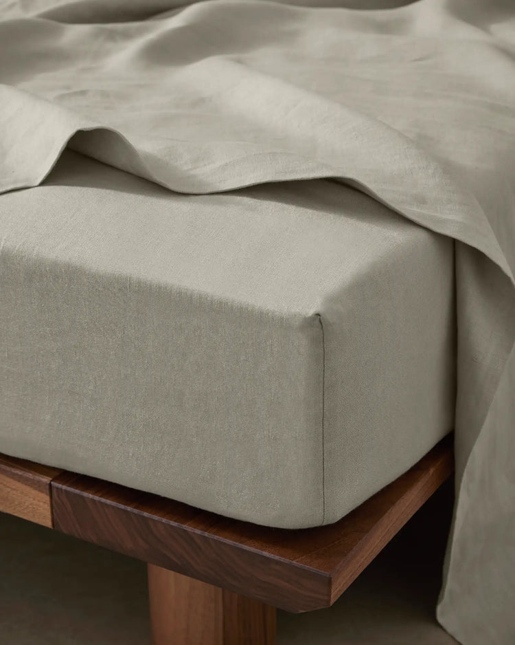 Ravello Fitted Sheet in Bone, European linen with extra thick banding detail, styled on wooden bed frame by Weave Home