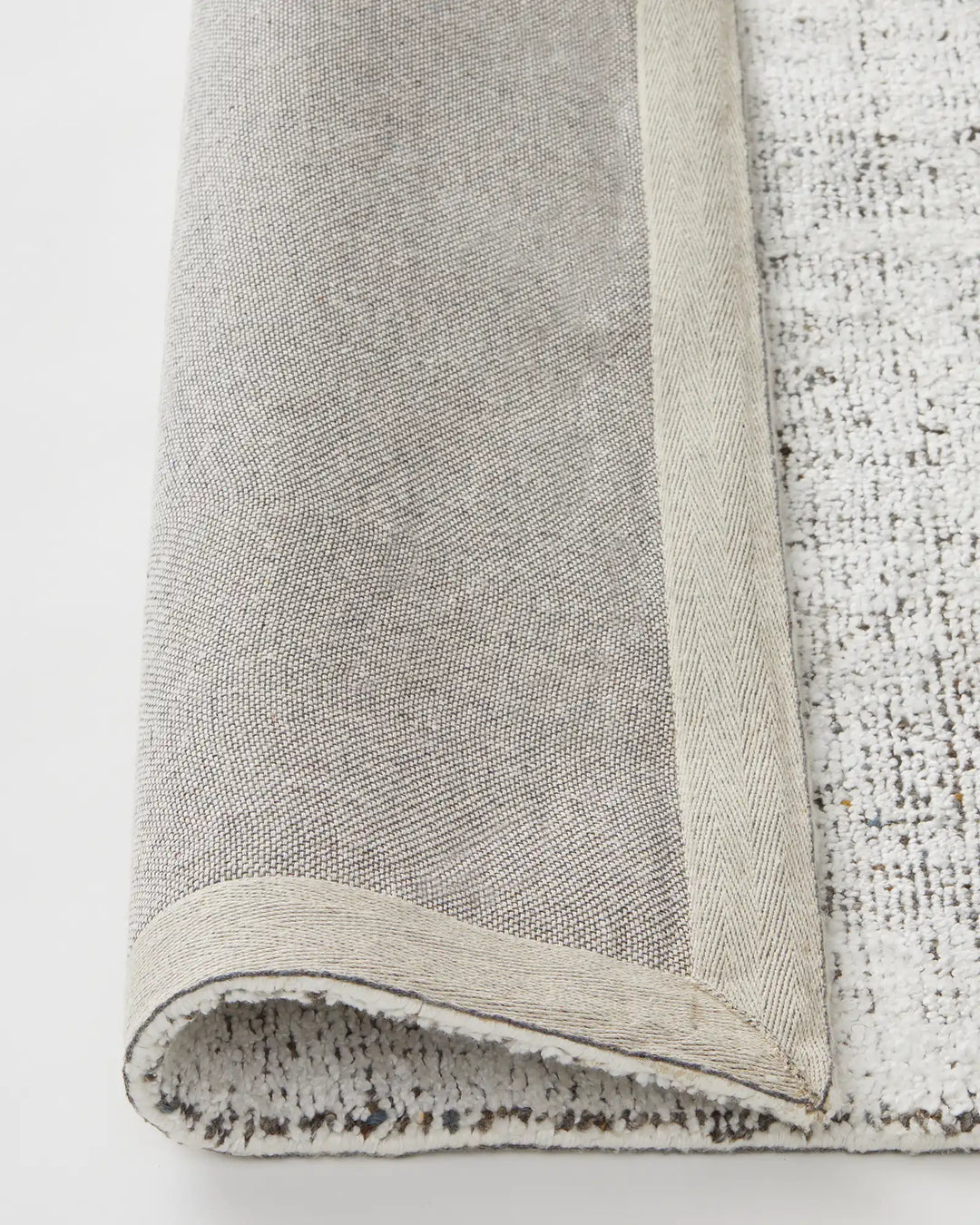 Matisse Marble rug detail showing cotton braided edge and backing, light grey viscose blend weave by Weave Home