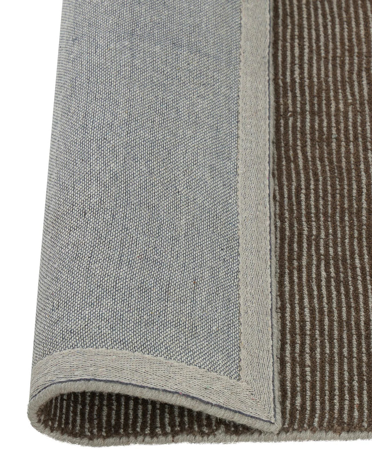 Remo Earth rug detail showing chocolate and pewter striped weave with lowered cut border, NZ wool by Weave Home