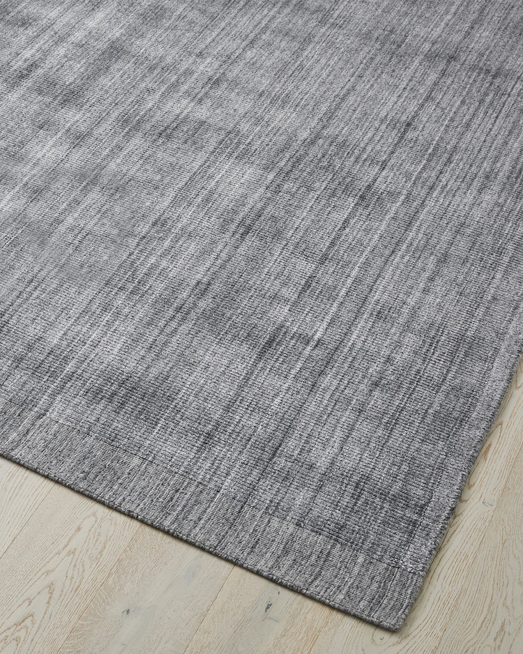 Travertine Pewter low-traffic rug corner view, showing hand-woven viscose blend with marbled texture and cotton backing, by Weave Home