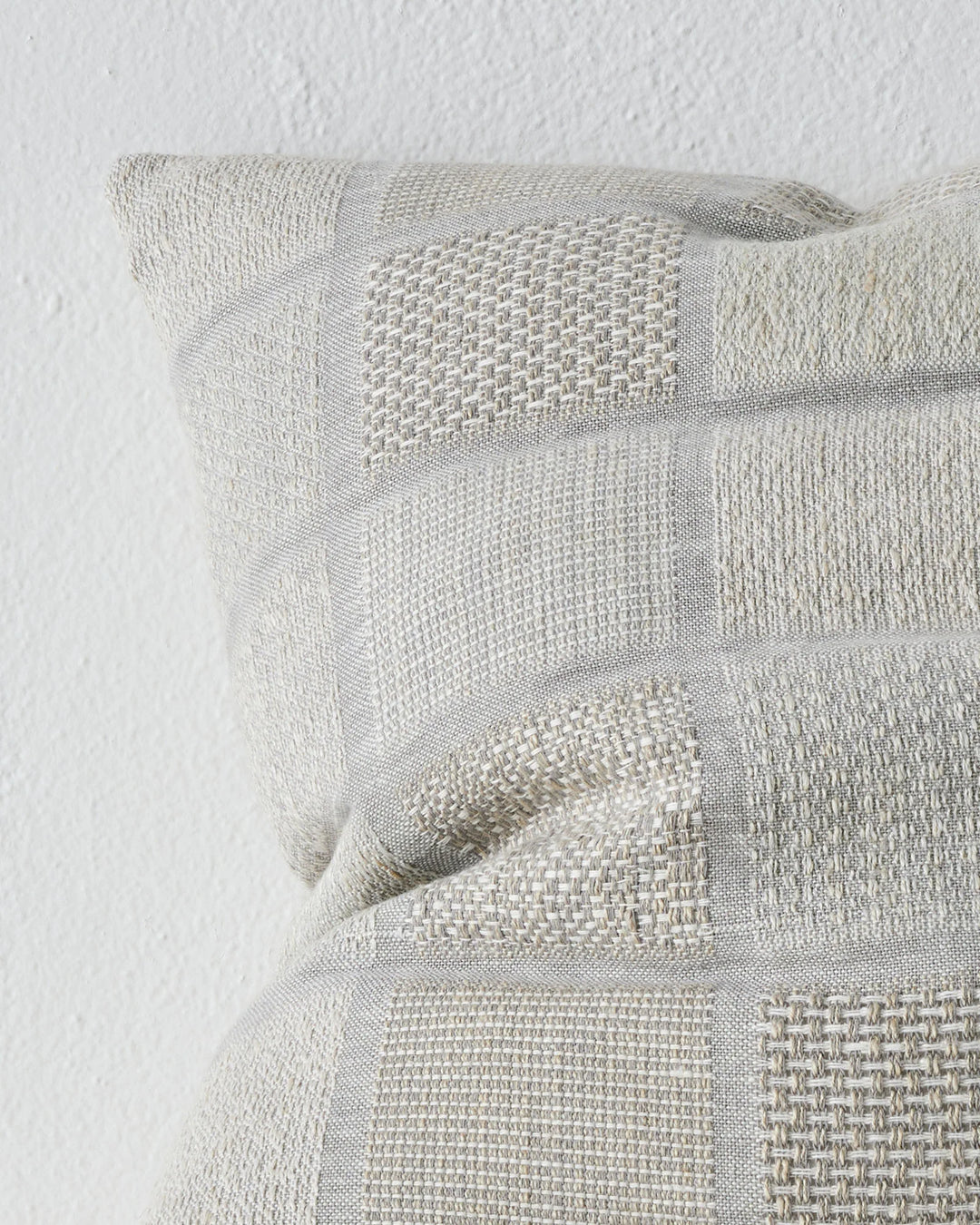 Bodrum Mist 50x50 cushion close-up, showing woven linen-cotton blend with geometric checkerboard panels and varied weave textures in soft blue tones by Weave Home