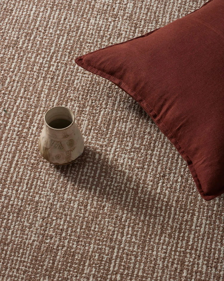Warm earthy interior with textured Kaia rug in mocha tones and Como cushion in deep rosewood, styled with ceramic mug for cozy home aesthetic