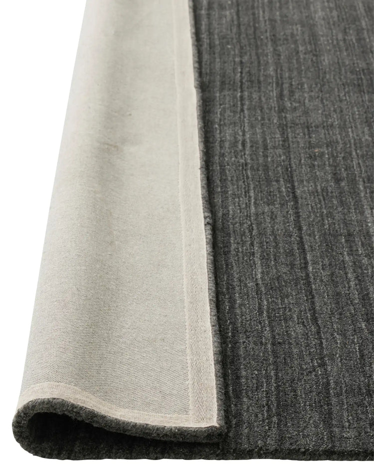 Gippsland Alloy rug corner detail showing charcoal viscose blend with cotton braided edge, 200x300cm by Weave Home