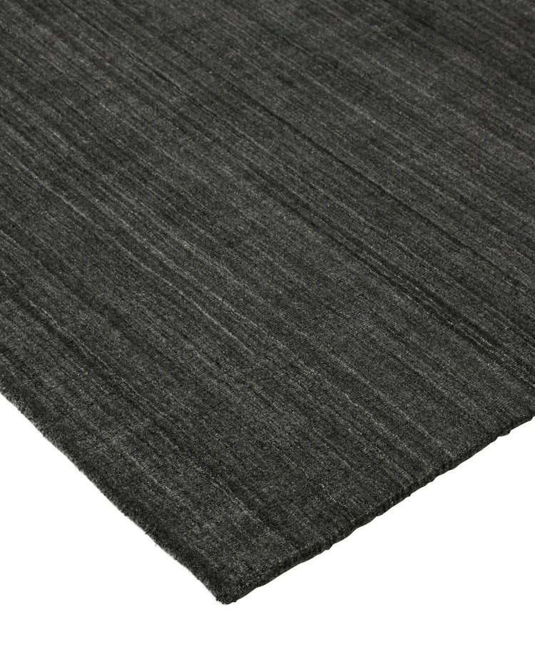 Gippsland Alloy rug corner detail, charcoal with grey-silver striped weave and cotton braided edge by Weave Home