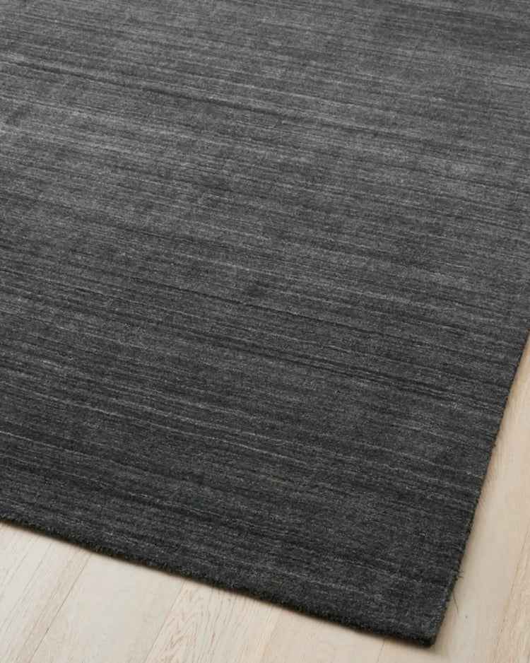 Gippsland Alloy hand-woven rug in charcoal with grey stripe detail, cotton braided edge visible, 200x300cm by Weave Home