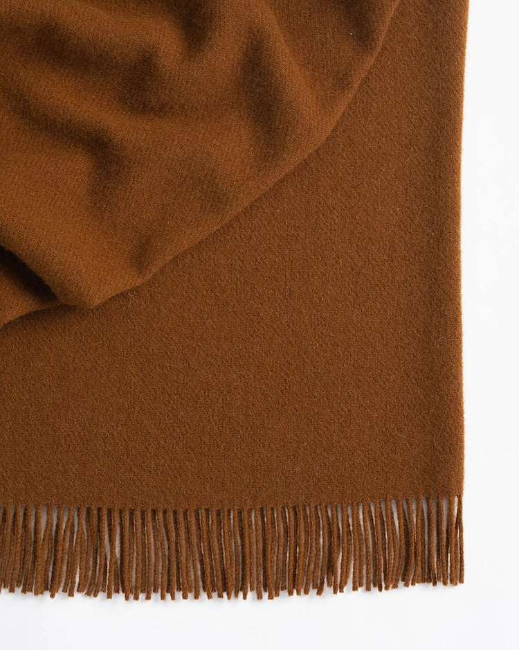 Nevis Spice throw in burnt brown lambswool with tassel fringe border detail, 130x200cm by Weave Home