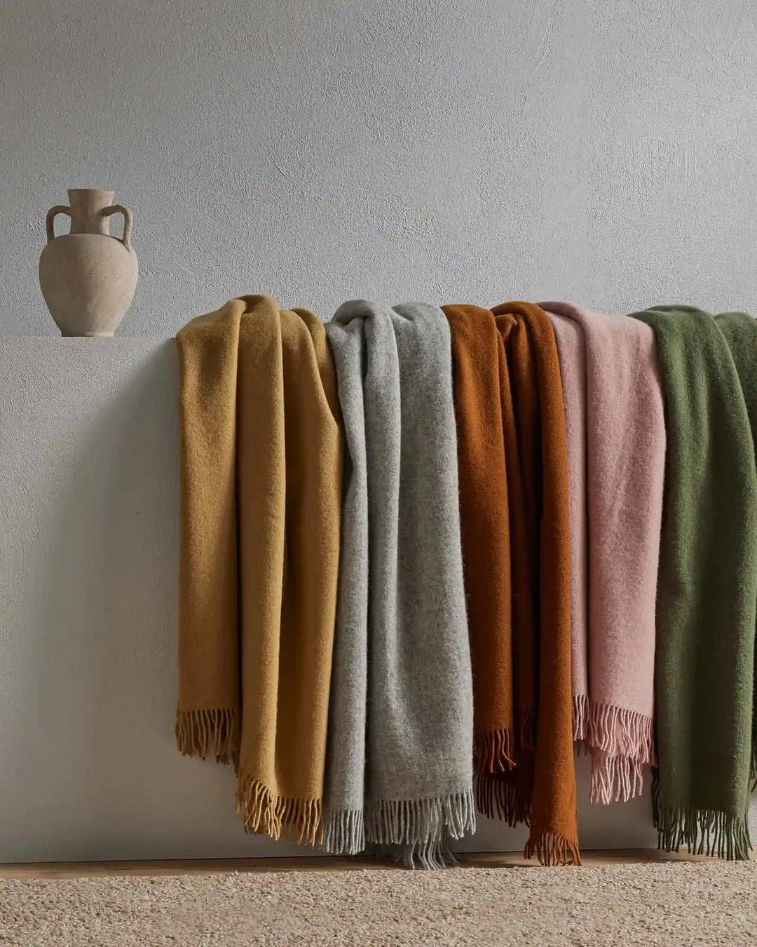 Nevis Spice throw in burnt brown lambswool with tassel border detail, displayed among colourway range by Weave Home