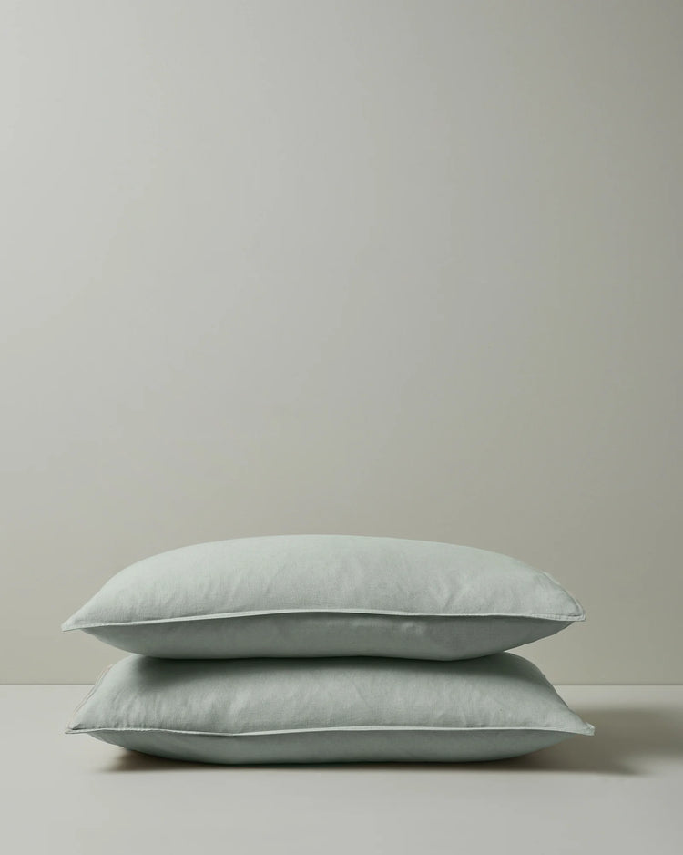 Ravello Pillowcase Set in sage, pair stacked showing soft European linen with top-stitched flanged edge by Weave Home