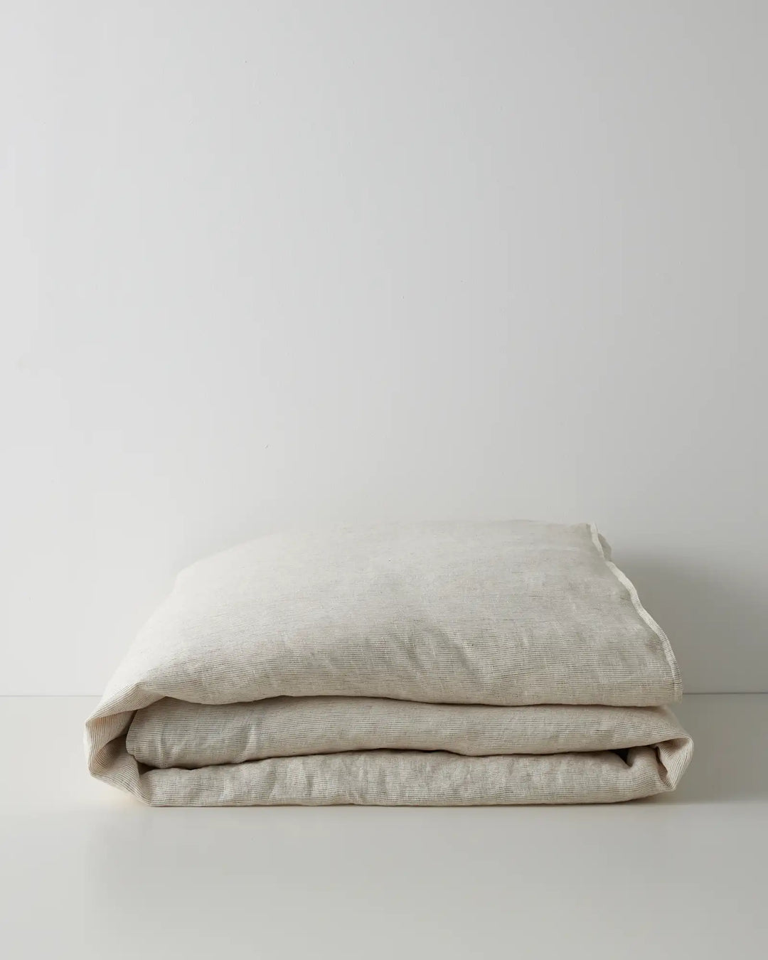 Sova Quilt Cover in Savanna pinstripe, folded flat to show soft European linen texture and neutral tone by Weave Home