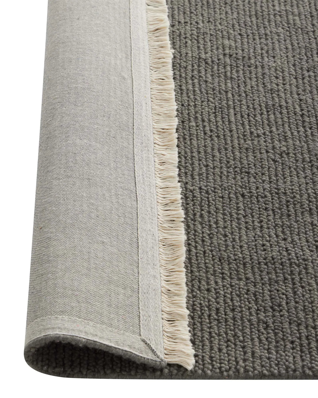 Fabien Echo textured wool rug in medium grey, showing chunky ribbed weave and cream fringe border detail, by Weave Home
