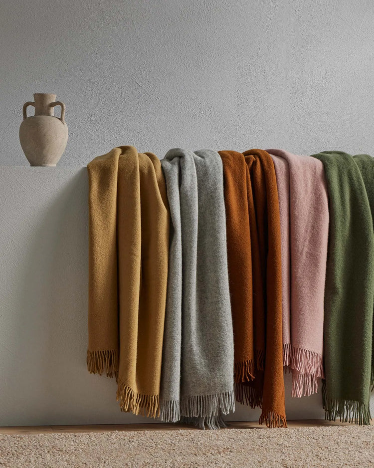 Nevis throws in Camel, Ash, Spice, Rose and Kelp — soft lambswool wraps with tassel borders by Weave Home