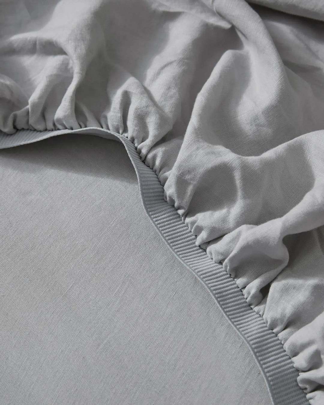 Ravello Fitted Sheet in silver, close-up detail of elastic edge and ribbed banding by Weave Home